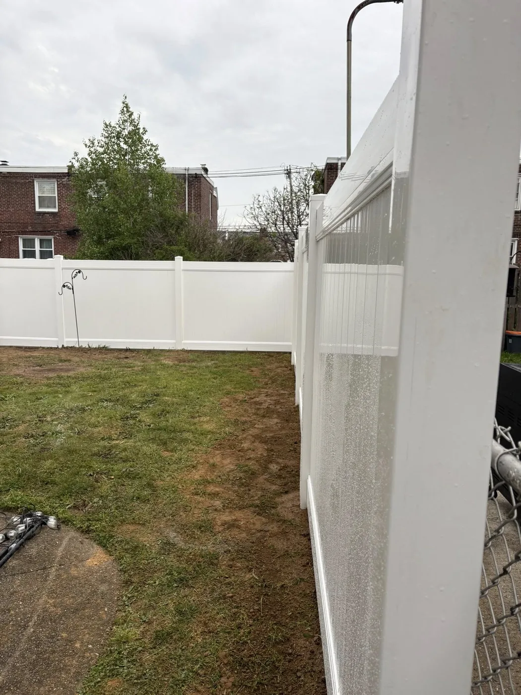 White vinyl fence adjacent to chain link transition